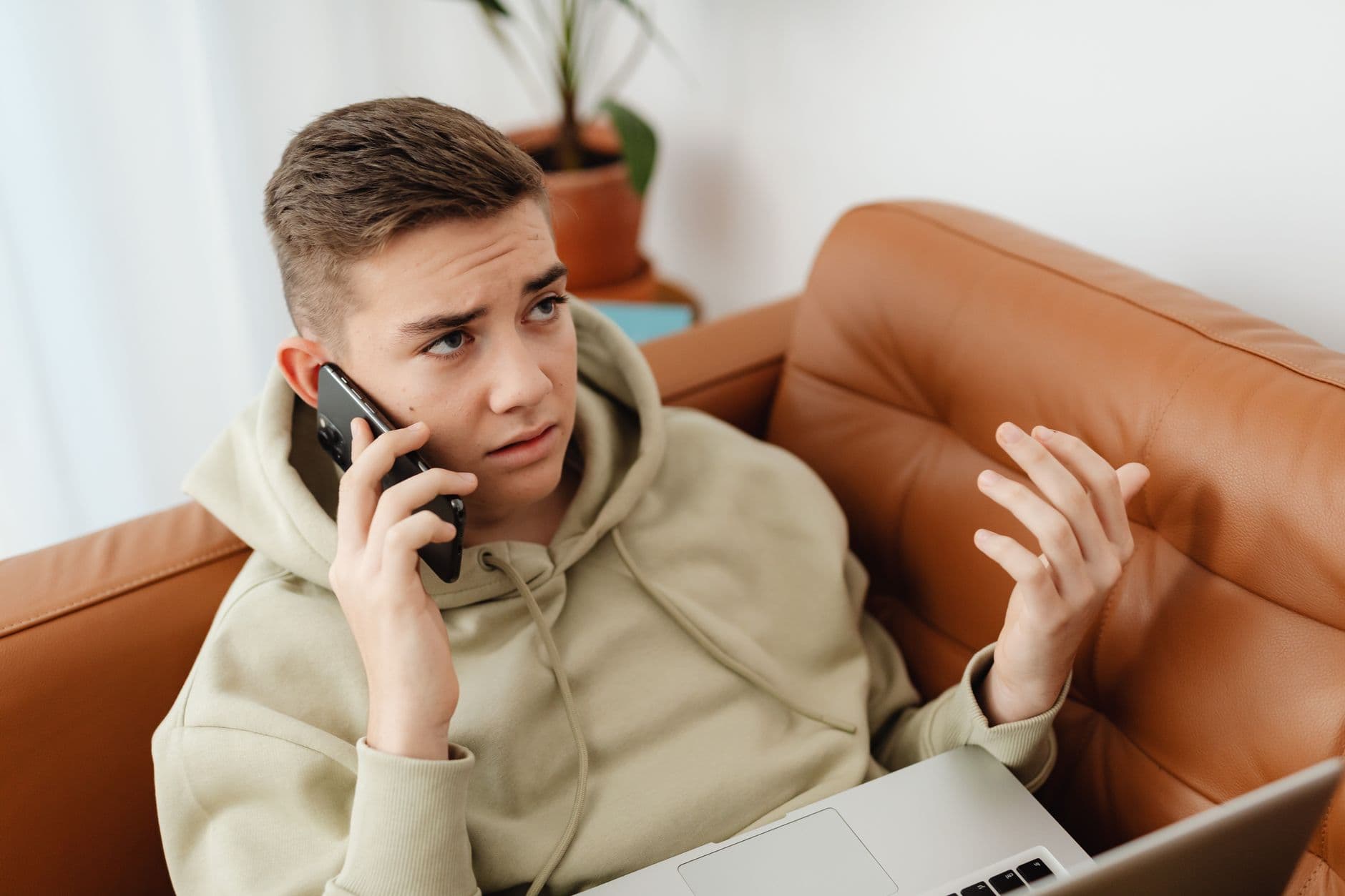 Worried teenager looking at phone showing cyberbullying signs
